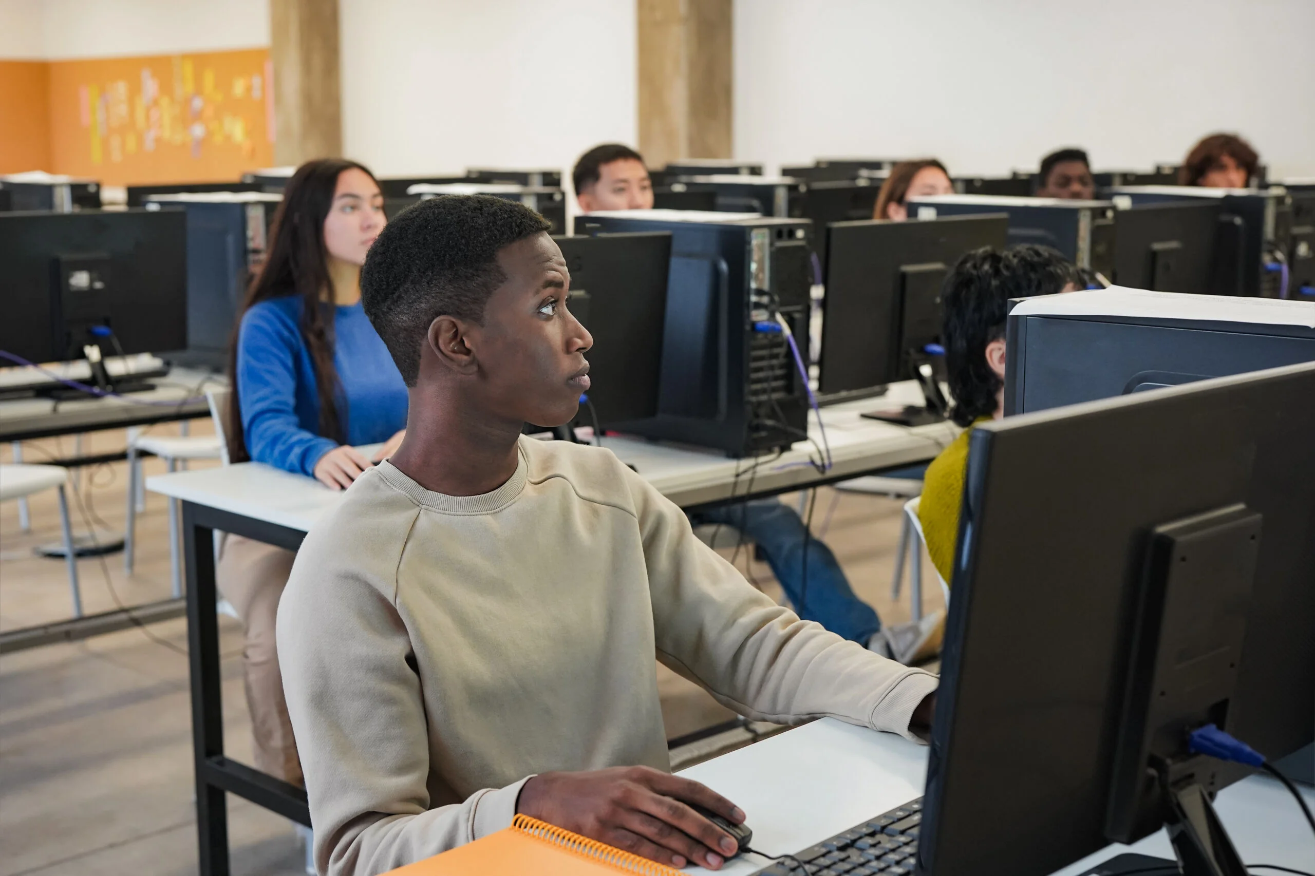 Young multiethnic students using computer inside university clas